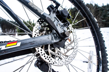 Obraz premium Close-up bicycle brake disc with tire in the snow. Minsk, Belarus - February 01 2020