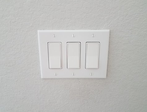 white wall with three buttons or switches