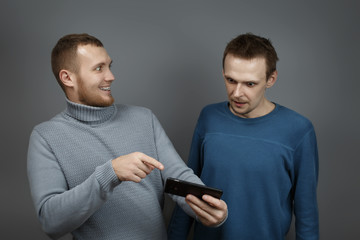 Two men with excitedly looking at the smartphone
