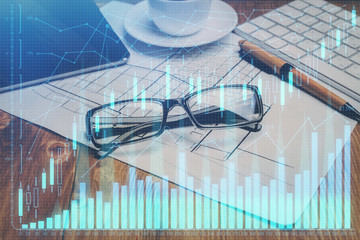 Financial chart hologram with glasses on the table background. Concept of business. Double exposure.