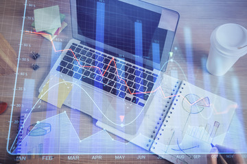 Double exposure of man's hands writing notes of stock market with forex chart.