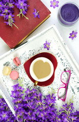 Vintage style Springtime creative composition layout with purple lilac style orchid flowers. Relaxing coffee break with old books for reading.