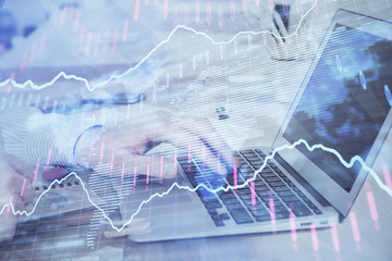Double exposure of stock market graph with man working on laptop on background. Concept of financial analysis.