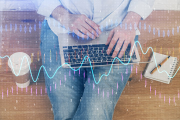 Forex graph with businessman working on computer in office on background. Concept of analysis. Double exposure.