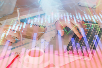 Forex graph with businessman working on computer in office on background. Concept of hardworking. Double exposure.