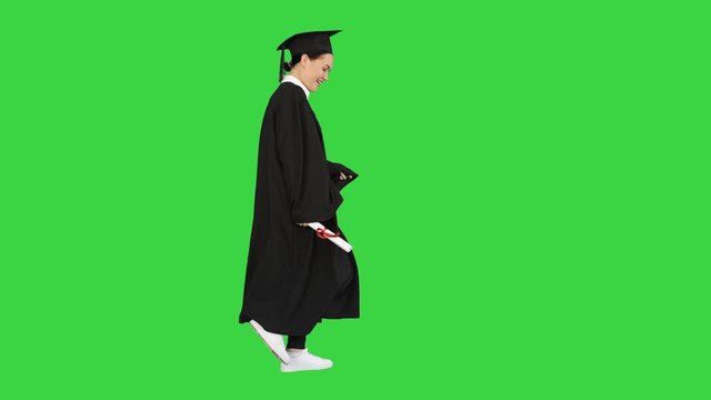 Caucasian woman in graduation robe dancing walking on a Green Screen, Chroma Key.