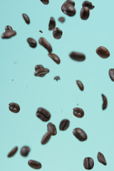 Falling coffee grains on a light blue background, freezing in motion