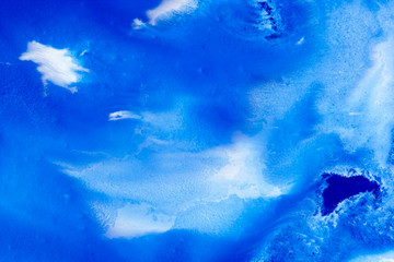 Fototapeta na wymiar Classical blue and white watercolor paint in abstract spreading forms similar to satellite imagery with arctic snow hills and seas with glaciers melting in macro. Stains of paint in macro for design.