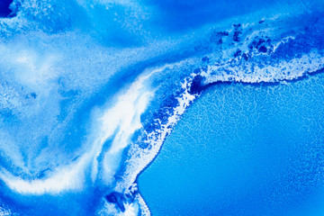 Classical blue and white watercolor paint in abstract spreading forms similar to satellite imagery with arctic snow hills and seas with glaciers melting in macro. Stains of paint in macro for design.