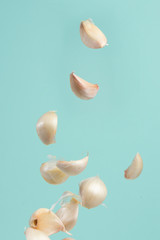 Garlic cloves falling on a light background. Isolate for design, freeze in motion.