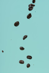 Falling coffee grains on a light background. Texture for design. Freezing in motion.