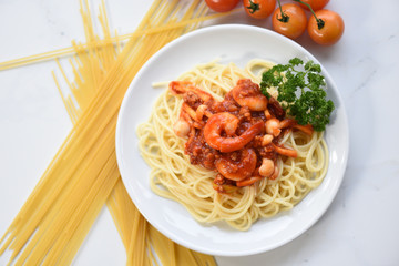 Spaghetti bolognese italian pasta with shrimp prawn served on white plate with tomato parsley in the restaurant italian food and menu concept / spaghetti seafood