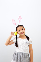 little child girl with easter bunny ears holding egg
