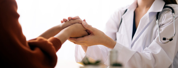 Doctor holding hands of patient  encouragement support cheering concept
