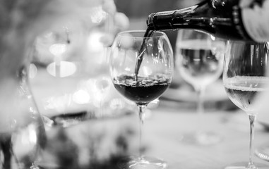 Waiter pouring wine into glass at luxury wedding