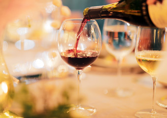 Waiter pouring wine into glass at luxury wedding