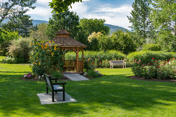 Recreation area with benches and wooden gazebo under blossoming sunflowers