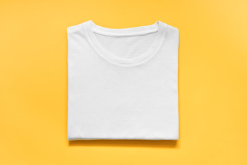 top view of folded white color t-shirt on yellow background, copy space, flat lay - Powered by Adobe