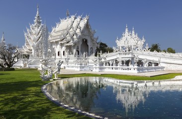 Obraz premium White Temple Exterior and Natural Park in Famous Wat Rong Khun Buddhist Complex, Chiang Rai Province, Thailand