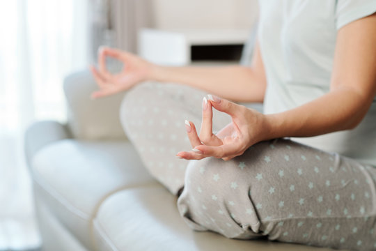 Close-up image of pregnant woman practicing yoga and meditating at home