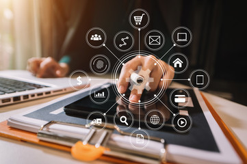 Businessman using mobile phone and laptop computer on white desk big data analytics with business intelligence concept. with VR chart and graph with icon