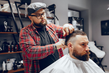 Man with a beard. Hairdresser with a client. Man in a red shirt