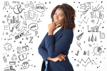 Hand drawn business pictures with woman with hand on chin. Side view of happy young African American businesswoman standing with hand on chin and smiling at camera. Business success concept