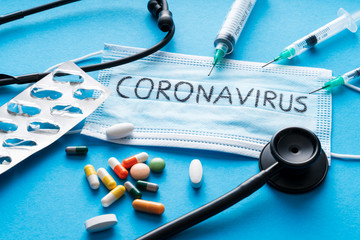 Protective face mask,pills, syringes and Stethoscope on blue background, against Novel coronavirus 2019-nCoV or Wuhan coronavirus . Hygiene and Healthcare concept