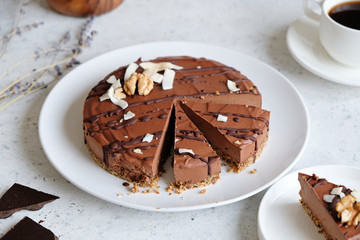 Homemade chocolate raw vegan cake - healthy dessert made from coconut milk, butter, cashew, cacao, walnut