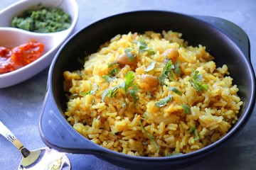 Indian comfort Food - Fresh Masala peanuts rice also known as Peanuts Pulav or rice khichdi. Garnished with coriander. Served hot with green chutney and mango pickle. with Copy space. 