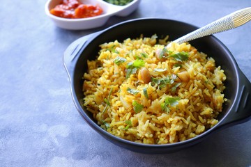 Indian comfort Food - Fresh Masala peanuts rice also known as Peanuts Pulav or rice khichdi. Garnished with coriander. Served hot with green chutney and mango pickle. with Copy space. 