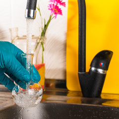 water purification specialist tap water pours into a glass flask.