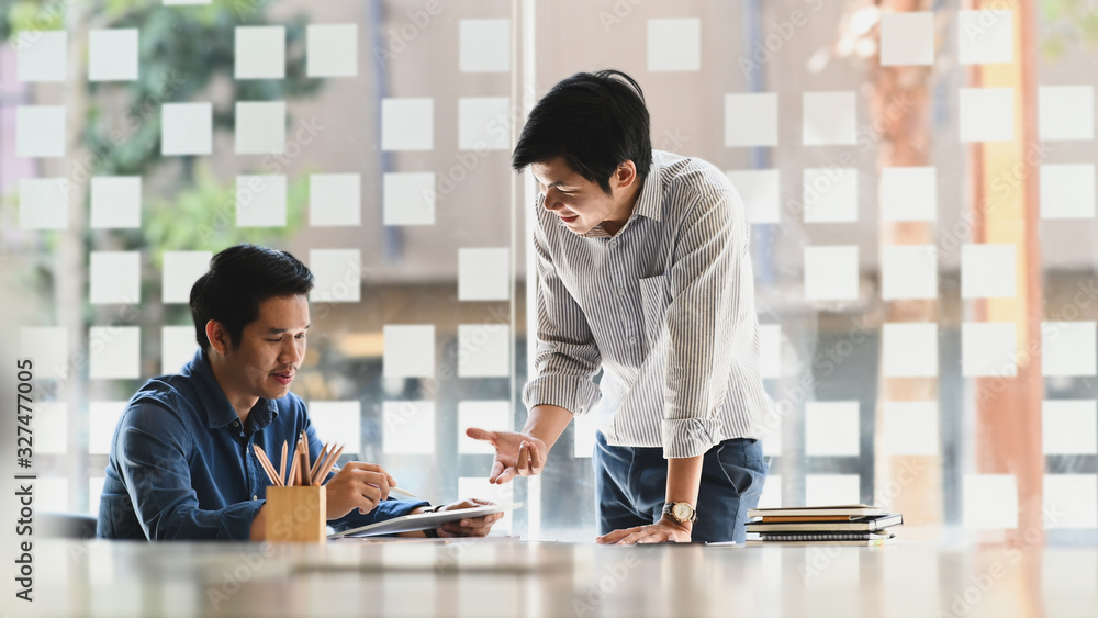 Poster photo of business development team while discussing/meeting at the modern meeting table with compute