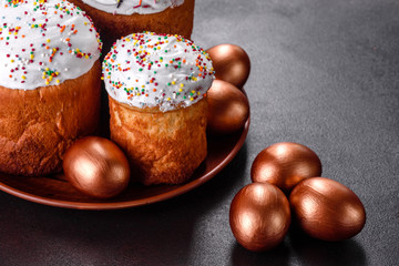 Easter eggs gold and bronze and Easter cake on a dark background