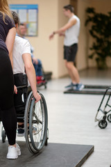 Obraz na płótnie Canvas disabled rehabilitation instructor teaches a girl with leg paraplegia to use an active wheelchair in an urban environment, rehabilitation of people with disabilities