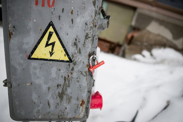 old rusty yellow electrical panel with hazard symbol