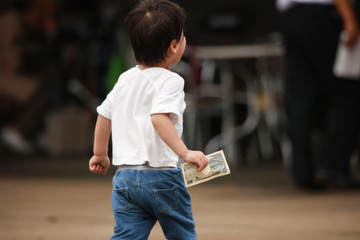 お金を手に持ち走り出す男の子