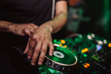 dj hands playing mixer in nightclub