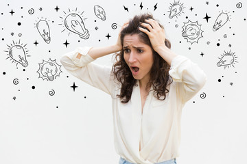 Stressed woman holding hands on head. Beautiful curly lady in eyeglasses with open mouth. Surprised, bad news concept