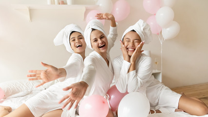Portrait funny Asian bride with bridesmaids sitting on bed