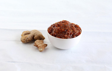 Ginger pickle, an Indian, vegetarian, and sweet and spicy side dish, and ginger, in a bowl.