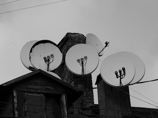 Many satellite antenna on the roof of an old house