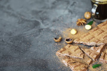 A bar of milk chocolate on the table. Chocolate with nuts and cinnamon.