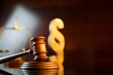 Law and justice concept. Judge’s gavel, scale and paragraph sign on the shining wooden brown...