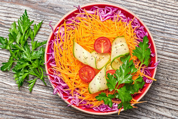 Vegan salad with red cabbage, cherry tomatoes, cucumber, carrot. Home made vegetarian food. Clean...