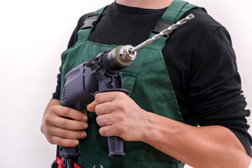 Handsome man with drill machine posing isolated on white. Worker in coverall