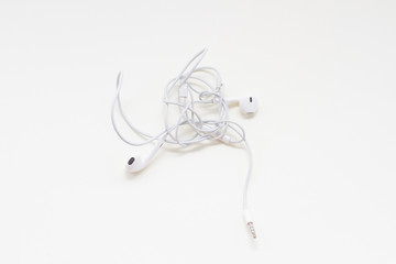a white wired earbuds with tangled wires