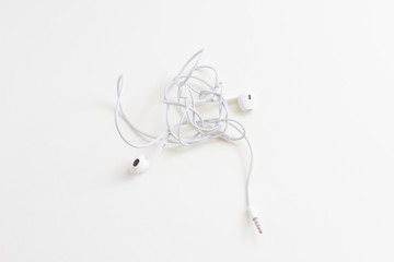 a white wired headphones with tangled wires