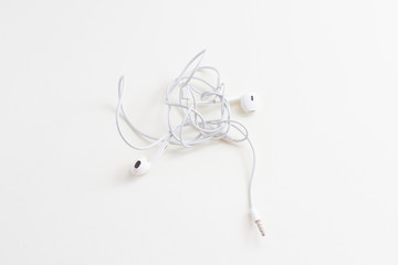 a white wired headphones with tangled wires