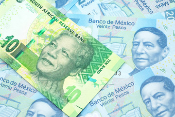 A close up image of a green ten rand bank note from South Africa in macro on a bed of Mexican twenty peso bank notes
